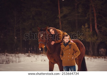 romantic couple with a horse in the winter forest