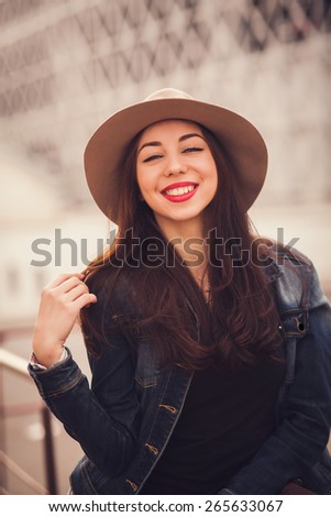 positive portrait of a stylish girl with a smile in a hat