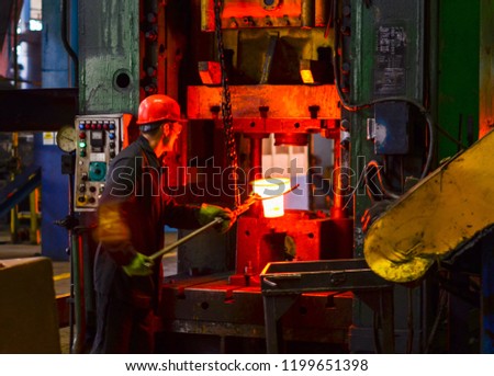 Blacksmith processes the red hot iron under a huge press. Metal forging, stamping under hammer forge at workshop of forge foctory. Blacksmithing, metallurgical, steelmaking, hot rolling mill Stock fotó © 