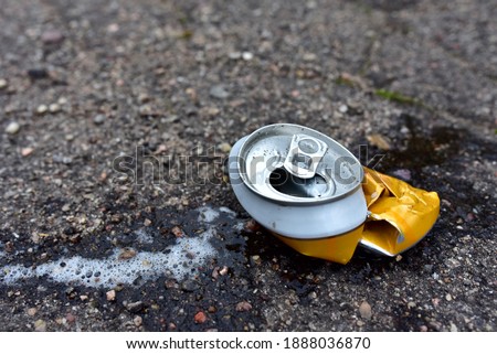Crumpled a beer can on asphalt with spilled alcohol. Discarded broken carbonated drink can at a road. Problem social, crime. Environmental pollution, waste, ecology. Crushed juce. Out of focus Photo stock © 