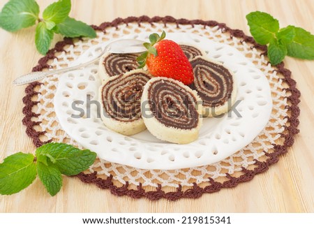 Bolo de rolo (swiss roll, roll cake) Brazilian chocolate dessert  with strawberry and mint. Selective focus