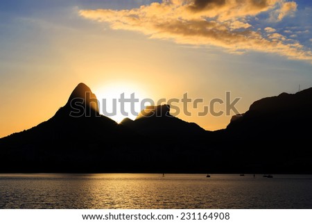 Sunset Lagoon Rodrigo de Freitas (Lagoa), ray of sun light behind the mountain Two brothers, Stone of Gavea, Rio de Janeiro, Brazil