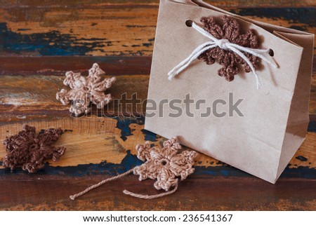 Brown crochet snowflakes for Christmas decoration of paper gift box. Selective focus