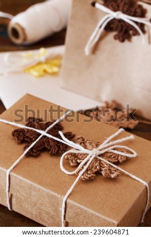 Brown and yellow crochet snowflakes for Christmas decoration of gift box, package and handmade greetings card. Selective focus