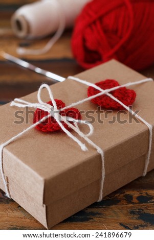 Saint Valentine decoration: handmade crochet red heart for gift paper box. Selective focus