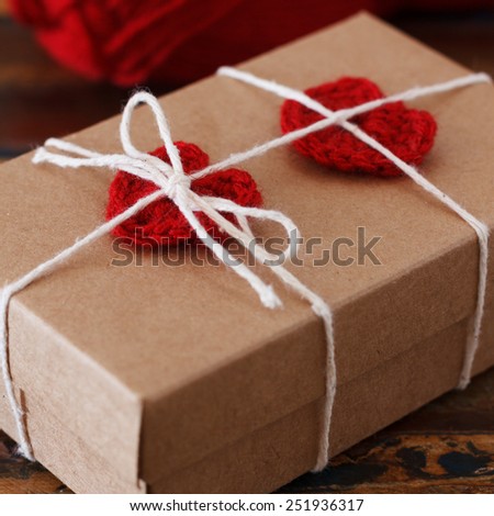Saint Valentine decoration: handmade red crochet heart for gift box. Selective focus. Square shape