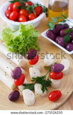 Cooking canape of Heart of palm (palmito), cherry tomatoes, olives. Selective focus