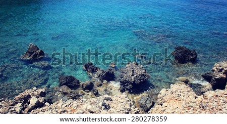 Calm blue sea and the rocks. Aged photo. Small bay near Cape Gelidonya. Vintage effect image. Rocky shore. Toned photo. Antalya Province, Turkey. Wide photo for site slider.