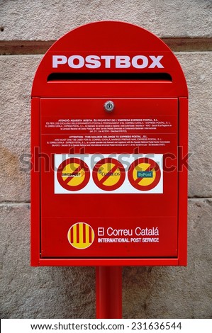 BARCELONA, SPAIN --25 JUNE 2014-- A red postbox from the Correu Catala international post service is affixed to a wall in Catalonia\'s capital.