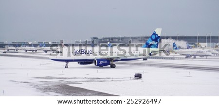 JOHN F. KENNEDY AIRPORT, NEW YORK --9 JANUARY 2015-- A Jetblue airplane is getting ready for take-off after a winter snowstorm at John F. Kennedy International Airport (JFK).