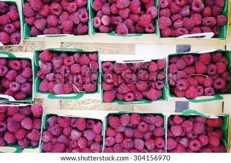 Fresh raspberries in containers at a French farmers market