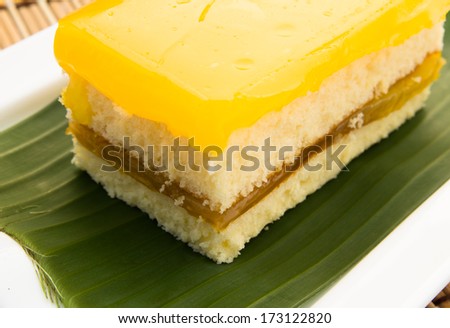 homemade sponge cake on green banana leaf in white plate