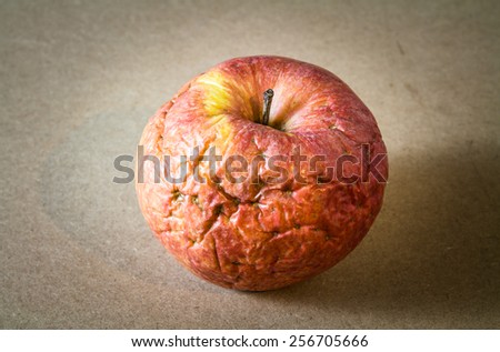 Old apple on wooden background,Wizened skin,Still life photography