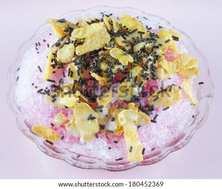 Shaved ice with syrup milk corn flakes and chocolate flakes.