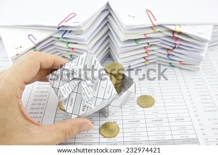 Man open gift box of gold coin place on finance account with pile of paperwork as background.
