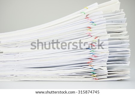 Stack paperwork with colorful paper clip overlap report of sales and receipt on white background.