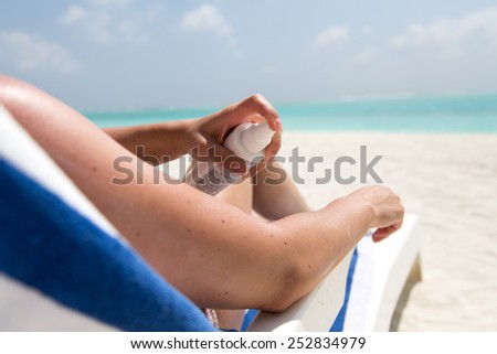 Woman protects her skin on the Beach and applies lotions