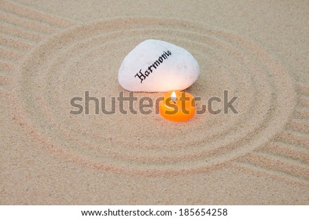 stone onto sand with patterns and the word harmony in german language