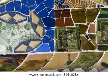 view on mosaic wall from ceramic broken tile, part of Tiled Bench in Parc Guell, one of Barcelona\'s biggest tourist attractions