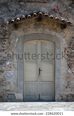 Old wooden door and glass canopy with roof tiles