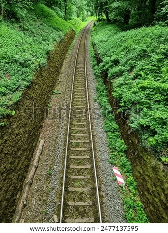 Similar – Foto Bild Gleisbett einer wenig benutzten Bahnstrecke, am Rand kahle Bäume. Schwarzweiß-Aufnahme.