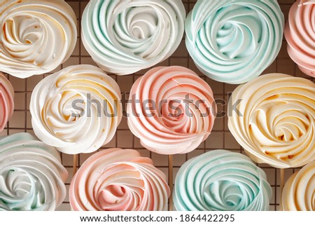 Colorful meringue or beze cookies with a wooden stick on the white background on a pastry grill Imagine de stoc © 
