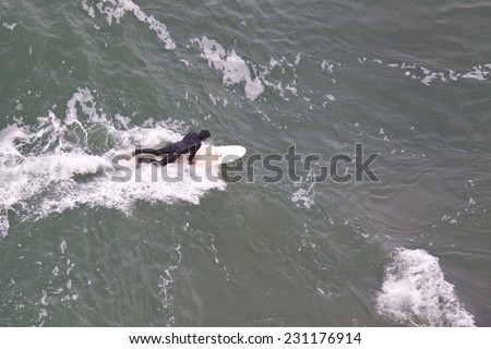 SAN FRANCISCO, CA, USA - APRIL 2010: Aerial View of surfer preparing to get up on the board and ride a wave. San Francisco Bay, California, USA