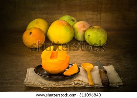 Still life with group of organic mangos on wooden background