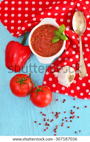 Gazpacho spanish vegetable soup with mint leaf on the red napkin and blue wood table with vintage spoon