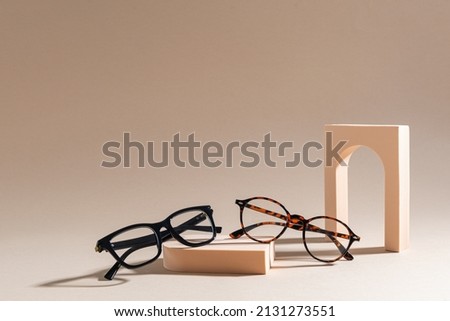 Two pairs of eyelass frames on beige background. Minimalism, summer fashion concept. Trendy eyeglasses still life in minimal stile. Optic store discount, sale. Copy space for text Foto stock © 