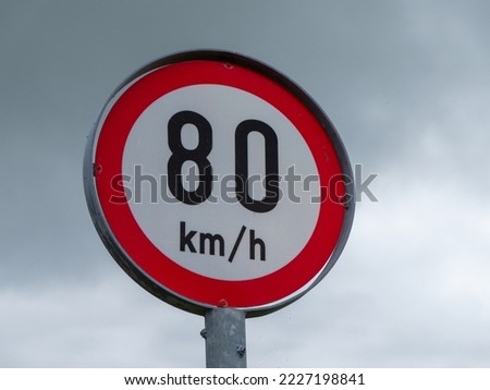 A road sign limiting the speed of 80 km per hour. A road sign against a cloudy sky. Stok fotoğraf © 