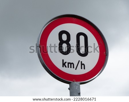 A road sign limiting the speed of 80 km per hour against a sky. Stok fotoğraf © 