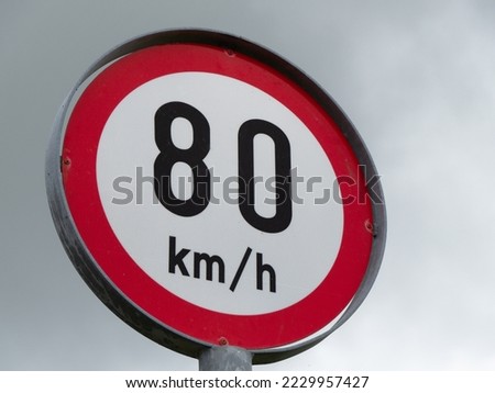 A road sign limiting the speed of 80 km per hour. A road sign against a cloudy sky. Close-up. Stok fotoğraf © 