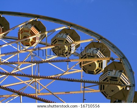 Different perspective on ferris wheel. Ferris wheel is isolated against beautiful blue sky.