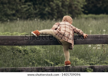 Similar – Image, Stock Photo Girls climb a fence in the spring in the garden.The concept of childhood, cheerfulness, carefree.