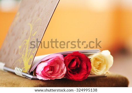 Beautiful roses with book on table