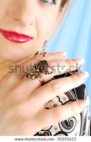 Beautiful woman\'s  fingers with modern ring and nice French manicure n the face with red lips background. .