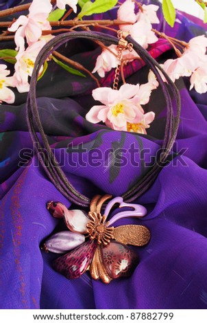 Luxury flower necklace  on purple background with pink spring sacra.