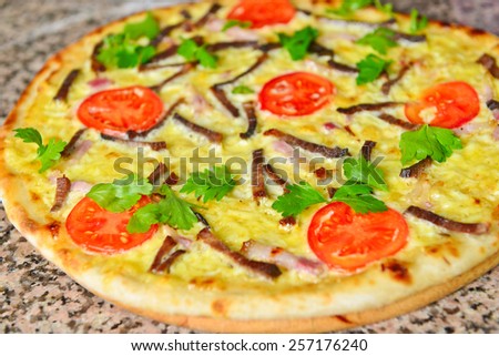 pizza preparation surrounded by ingredients with beef and tomatoes