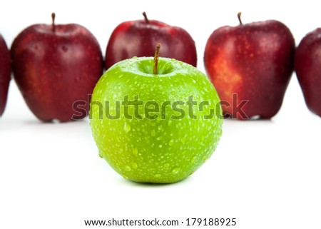 maroon apples lined up in a row and green apple closeup on a white background