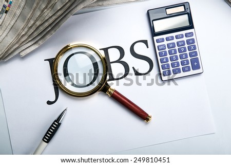 title jobs with loupe, pen, newspapers and calculator