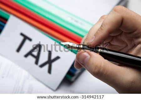 pen in hand and metaphor for the payment of taxes