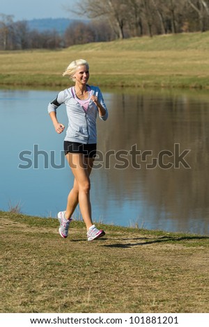 Running woman outdoor sport by river bank sunny day