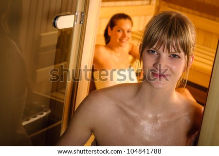 Sweaty blond woman getting out of sauna at luxury spa