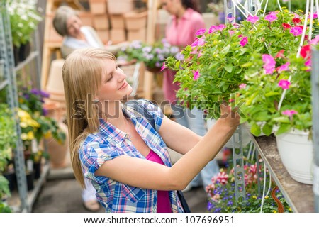 Young woman shopping flowers at market garden centre