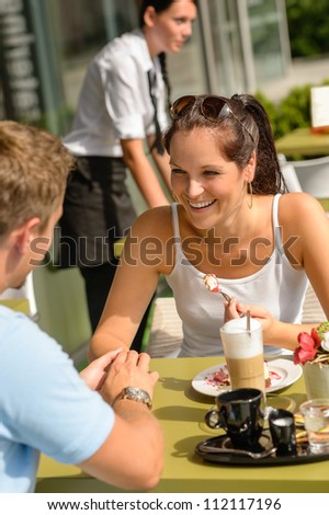 Couple enjoy coffee dessert restaurant sunny terrace eat cheesecake