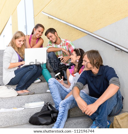 Students enjoying break on school steps laptop happy teens college
