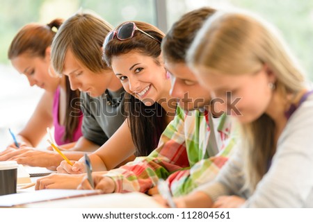Students writing at high-school exam teens study campus academic class