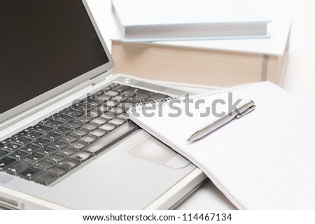 Office desk laptop with notepad and pen on white background