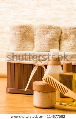 Natural cosmetic products with basket of towels on wooden floor